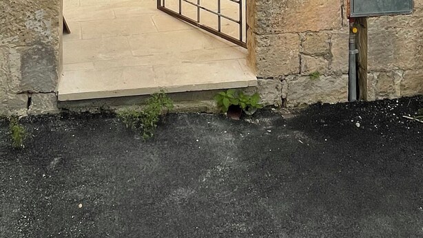An arched stone entrance with a wooden gate, a sign with text, and a utility box. - Giurdana 0dB - One Bedroom House, Sleeps 3 (San Cesario di Lecce)