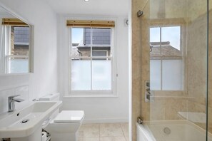 Une salle de bain avec une douche, un lavabo et des toilettes.