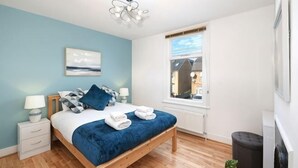 A bedroom with a bed, bedside tables, a window, and a view of the outside. - Big Family Home! FREE Parking, Fast WiFi, Garden (Kingston upon Thames)