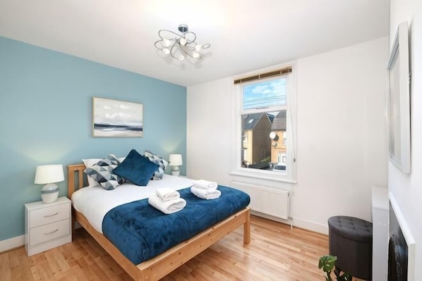 A bedroom with a bed, bedside tables, a window, and a view of the outside. - Big Family Home! FREE Parking, Fast WiFi, Garden (Kingston upon Thames)