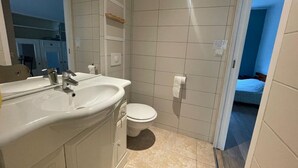 A small bathroom with a sink, toilet, and mirror. - Studio 2 in quiet renovated 2023. Garage (Saint-Pierre-des-Corps)