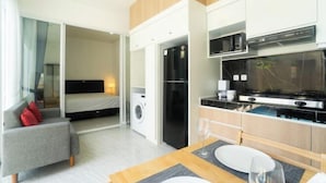 Una habitación de hotel moderna con comedor, kitchenette y un dormitorio separado.