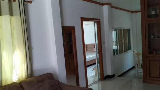A room with a brown sofa, a wooden cabinet, and a mirrored closet door. - Centraltesco/ NightSafari/4Bedroom Villa (Chiang Mai)