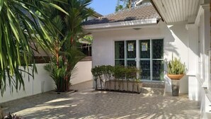 A house with a tiled patio, a palm tree, and a potted plant. - Centraltesco/ NightSafari/4Bedroom Villa (Chiang Mai)