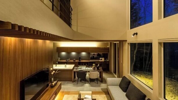 A modern interior with a dining area, kitchen, and a large window offering a view of trees. - Brile Takayama Yamada (Takayama)