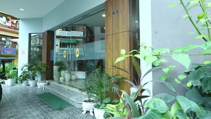A hotel entrance with a modern design, potted plants, and a visible sign indicating room number 101. - Laughing Lama Hotel Dewaling (Phuntsholing)
