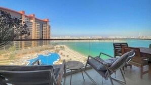 Ein Balkon mit Blick auf Strand und Schwimmbad.