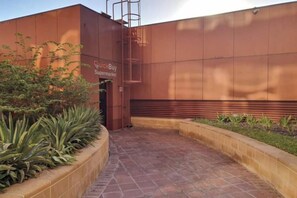 A QuickBuy Supermarket entrance with a tiled pathway and a planter with green plants. - bnbme Luxury Seaview Retreat with Private Beach (Dubai)