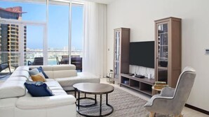Ein modernes Wohnzimmer mit einer Couch, einem runden Couchtisch, einem Fernseher und einem Bücherregal.