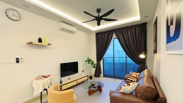 A modern living room with a brown leather sofa, a yellow armchair, a flat-screen TV, a ceiling fan, and a large window with curtains. - Elegant 3-Bedroom Fully Air-Con @ Vista Sentul (Kuala Lumpur)