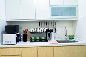 A kitchen with white cabinets, a microwave, a coffee maker, and a dish rack. - Elegant 3-Bedroom Fully Air-Con @ Vista Sentul (Kuala Lumpur)
