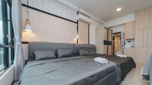 A modern bedroom with a large bed, a bedside table, a wardrobe, and a window with curtains. - Molek Little Joy Studio 4pax Bathtub with Balcony (Plentong)