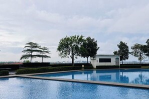 A swimming pool with a clear view of the sky and trees in the background. - Molek Little Joy Studio 4pax Bathtub with Balcony (Plentong)
