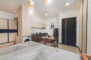 Un espace de vie compact comprenant un coin repas, une kitchenette et un placard.