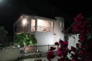 A two-story building with a balcony, a tree in front, and a fence. - Villa Mykines (Mykines)