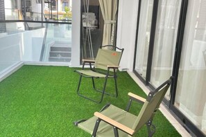 A balcony with artificial green flooring and two chairs. - Happiness Stay (20 Pax) With Karaoke, Snooker, Mahjong Table (Ipoh)
