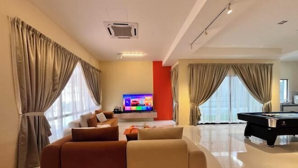 Un salon moderne avec un canapé, un téléviseur à écran plat et une table de billard.