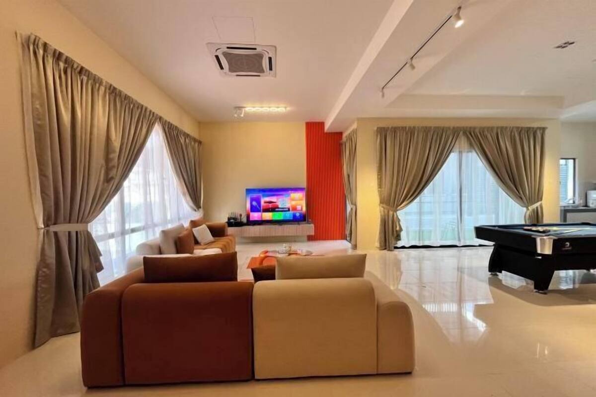 Una sala de estar moderna con un sofá, un televisor de pantalla plana y una mesa de billar.