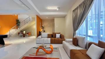 Una sala de estar moderna con un sofá, una mesa de centro y una escalera que conduce a otro nivel.
