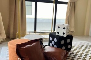 A room with a view of the sea, a checkered floor, a brown leather chair, and a black and white polka-dotted object on a white table. - Happiness Stay (20 Pax) With Karaoke, Snooker, Mahjong Table (Ipoh)