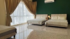 Une chambre d’hôtel avec deux lits, une grande fenêtre avec des rideaux, un climatiseur fixé au mur et un sol carrelé.