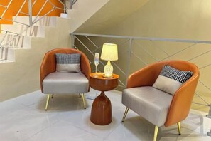 Two armchairs with cushions, a small table with a lamp, and a staircase in the background. - Happiness Stay (20 Pax) With Karaoke, Snooker, Mahjong Table (Ipoh)
