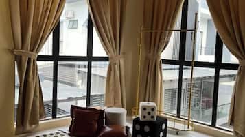 Una habitación con ventanas amplias, piso a cuadros y una persiana.