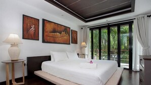 Un'ampia camera da letto con un letto grande, due lampade ai comodini e due quadri appesi al muro.
