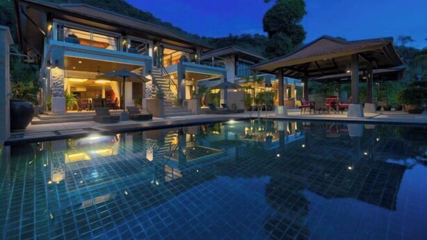 Una moderna località turistica con piscina, area salotto all'aperto e portico coperto.