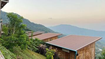 A hillside with wooden cabins, each with a sloped roof.