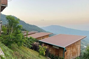 A hillside with wooden cabins, each with a sloped roof. - Mon Sa Kiang Dao (Mae Rim)