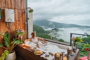 A person relaxing in a bathtub with a view of a mountainous landscape. - Mon Sa Kiang Dao (Mae Rim)