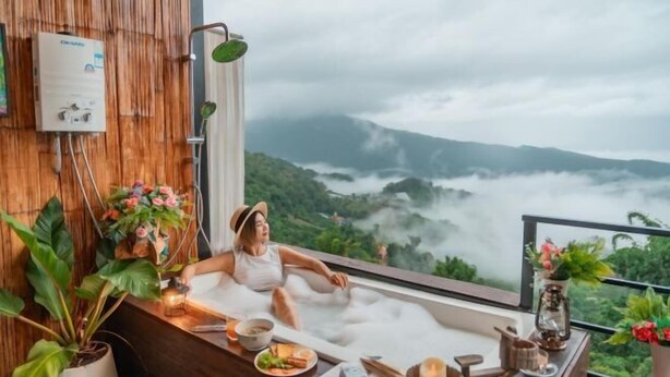A person relaxing in a hot tub with a view of a mountainous landscape. - Mon Sa Kiang Dao (Mae Rim)