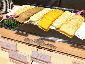 A display of various cakes and pastries on a tray, with labels in a foreign language. - LiVEMAX Sakishima Cosmo Tower Hotel (Osaka)
