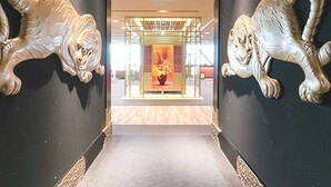 En gang med to store, metalliske tigerskulpturer på hver side.