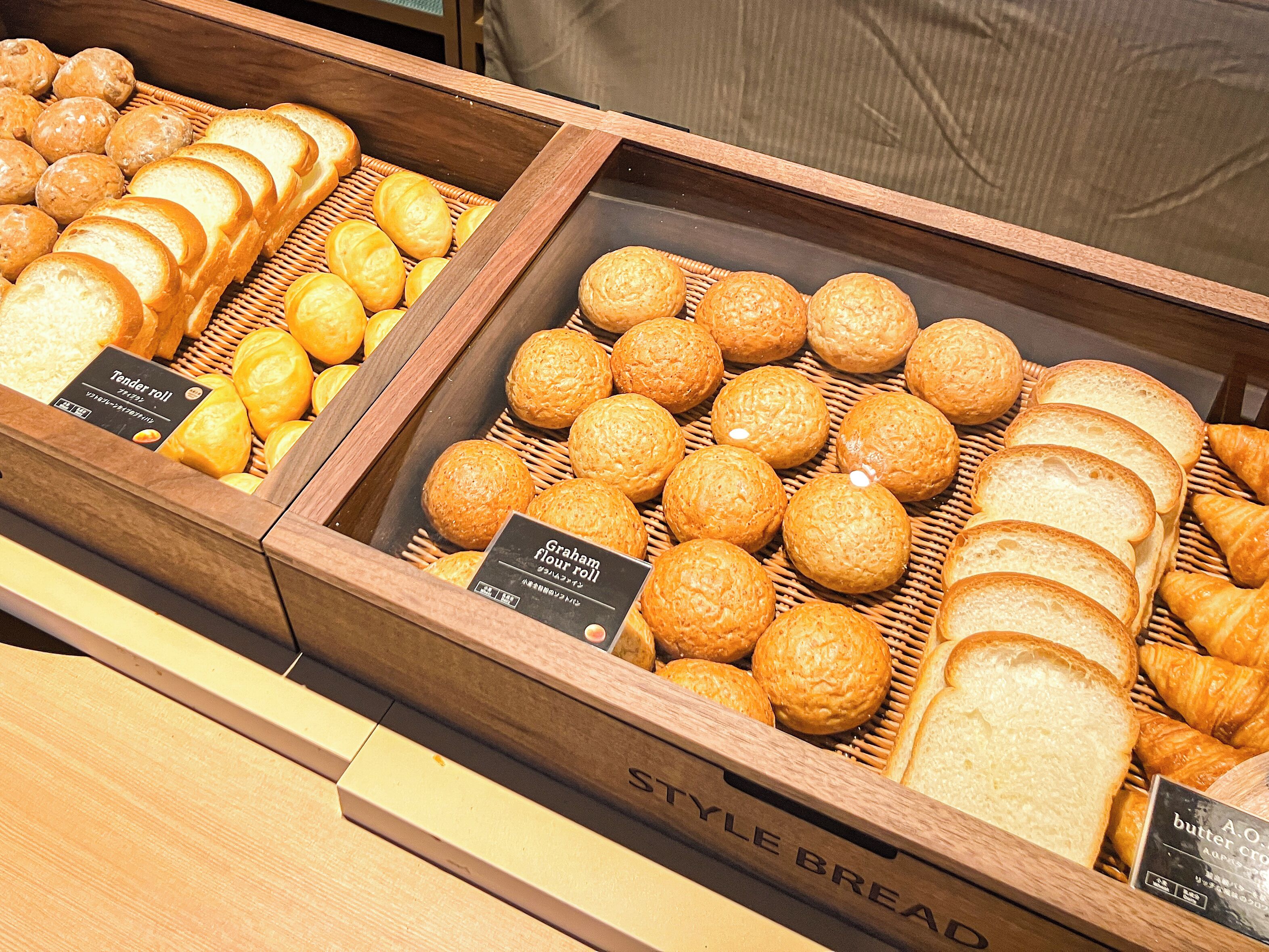 Une vitrine de boulangerie présentant divers produits de boulangerie, comme du pain et des pâtisseries.
