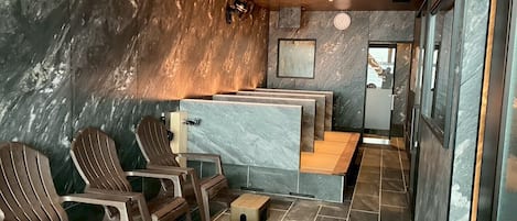 A spa area with wooden chairs, a marble counter, and a tiled floor.
