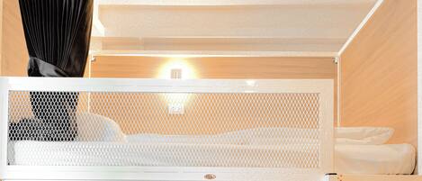 Un lit superposé avec un lit inférieur et un bureau escamotable.