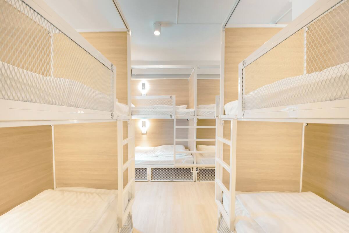 Une chambre avec des lits superposés, des murs en bois et un plafond blanc.