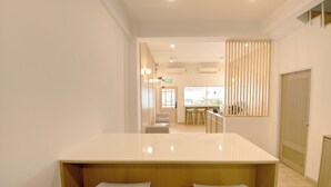 Un hall d’hôtel moderne comprenant un comptoir d’accueil, un espace salon et une vue sur la salle à manger.