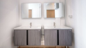 Une salle de bain moderne avec deux vasques, des armoires à miroir et un plancher en bois.