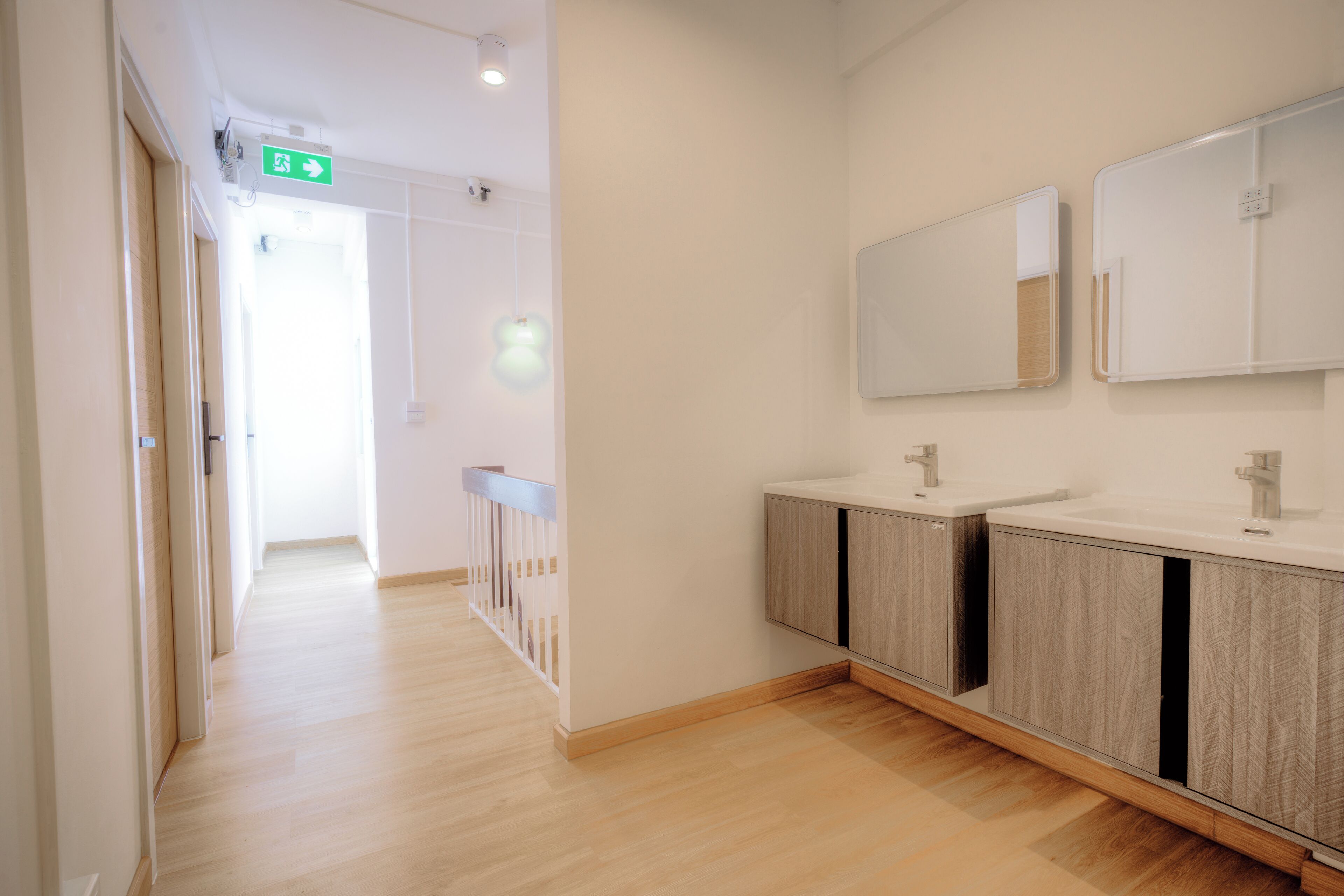 Une salle de bain moderne avec des meubles en bois et deux lavabos.