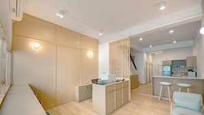 Une cuisine moderne dotée d’un îlot central, de tabourets de bar et d’une cloison en bois.
