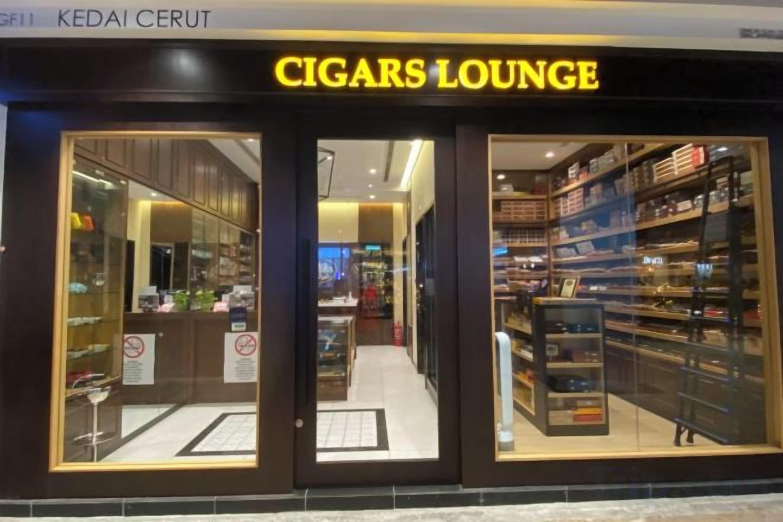 A storefront with a sign reading 'CIGARS LOUNGE' and glass display windows.