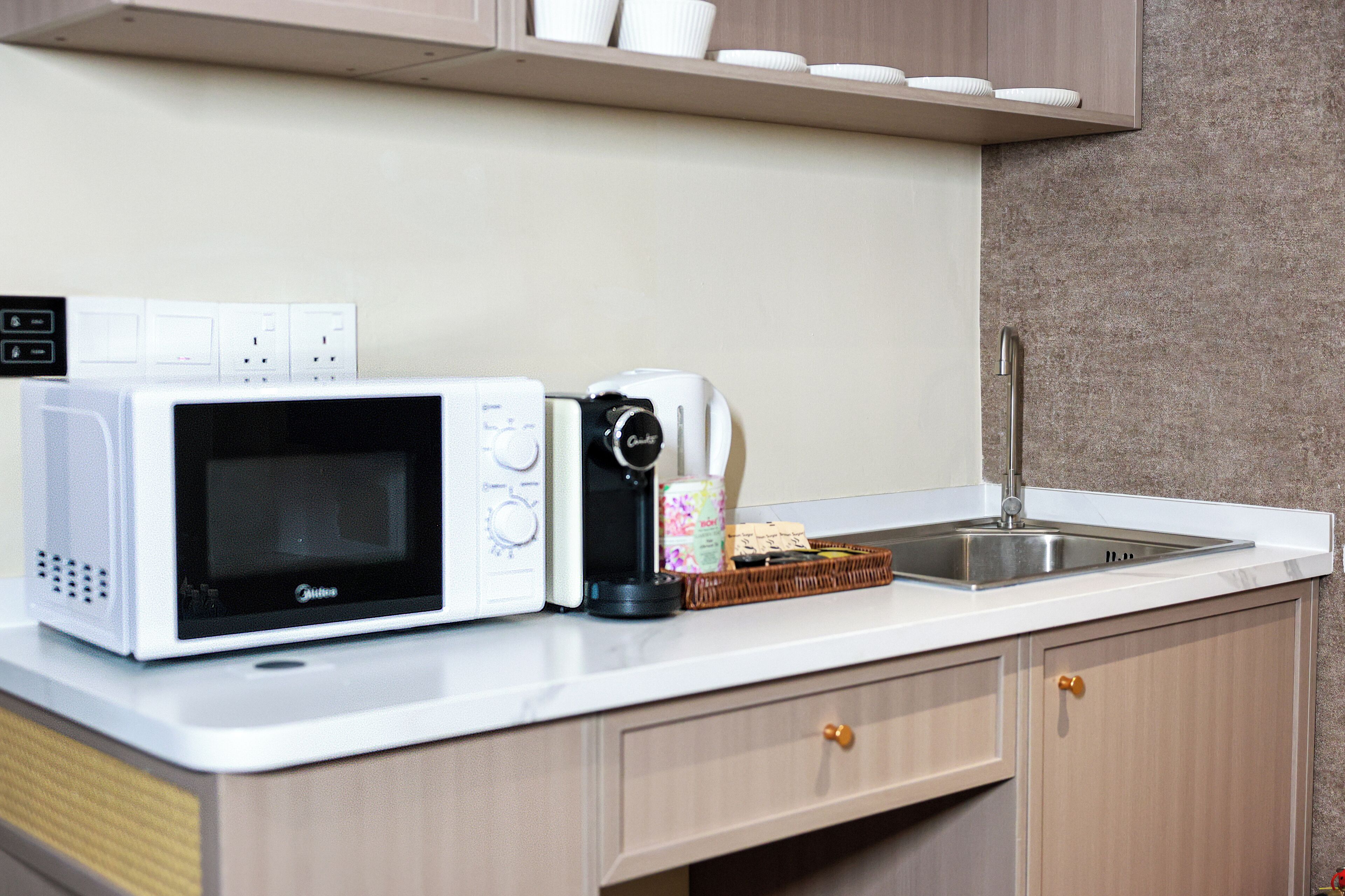 A compact kitchen with a microwave, toaster, and sink.