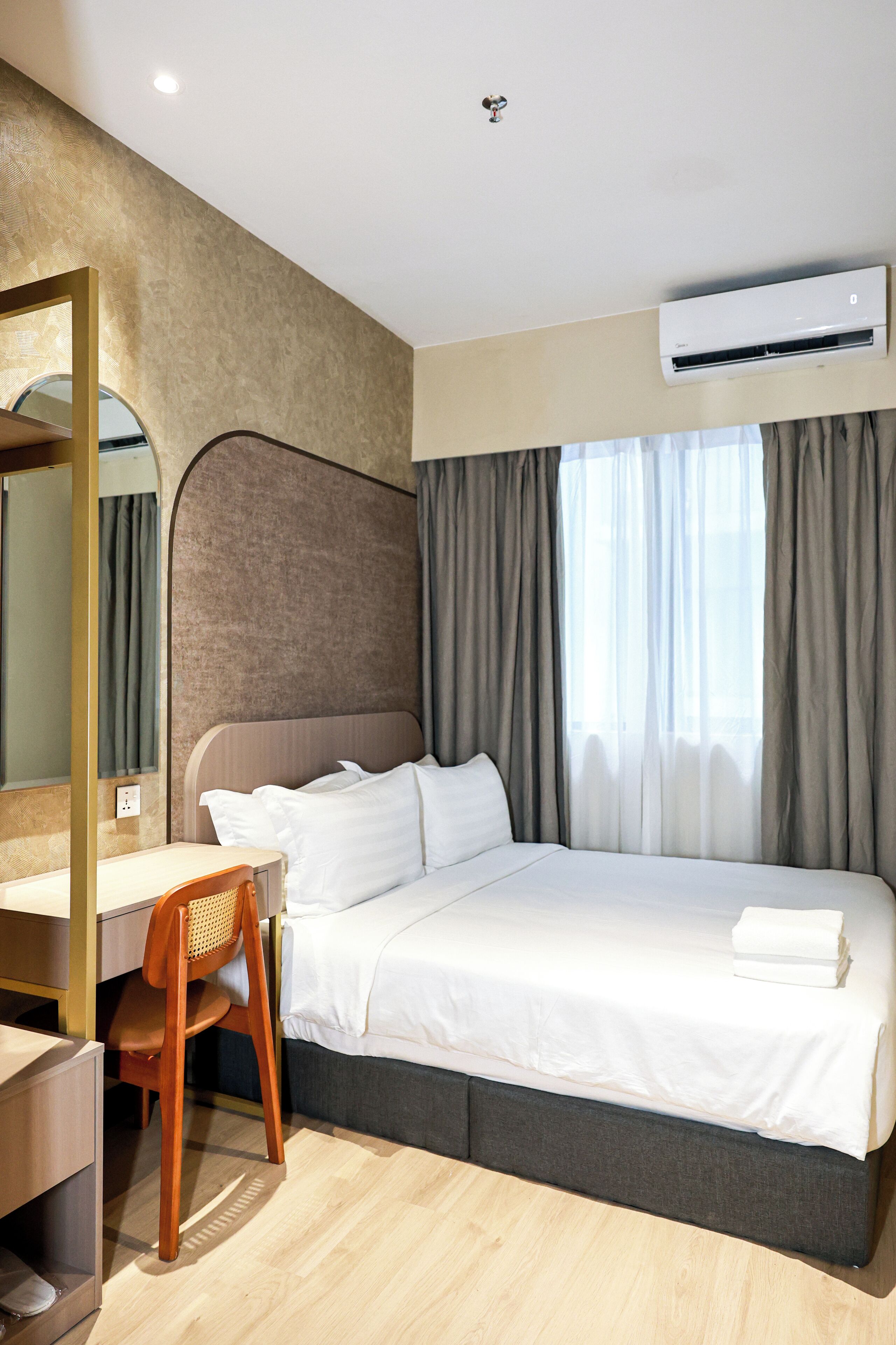 Moderni hotellihuone, jossa on suuri sänky, työpöytä ja tuoli.