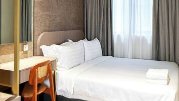 Moderni hotellihuone, jossa on suuri sänky, työpöytä ja tuoli.