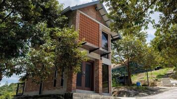 A small, single-story building with a brick facade, a flat roof, and a door.
