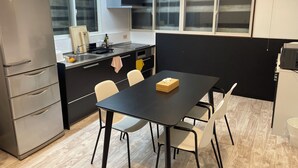 Una cocina moderna con una mesa de comedor, sillas, un refrigerador y una ventana.