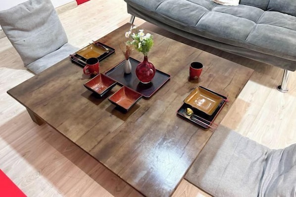 A wooden coffee table with multiple trays and a vase of flowers. - Empire City Signature Studio Suites (Petaling Jaya)